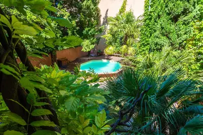 a swimming pool in a garden with trees and plants at Le Gîte du Carmel in Carpentras