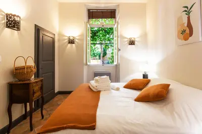 a bedroom with a white bed with two pillows on it at Le Gîte du Carmel in Carpentras