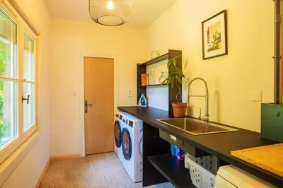 a kitchen with a sink and a washing machine at Le Gîte du Carmel in Carpentras