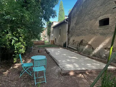 two chairs and a table in front of a building at Mazet au pied des Alpilles, avec Piscine & Pétanque in Salon-de-Provence