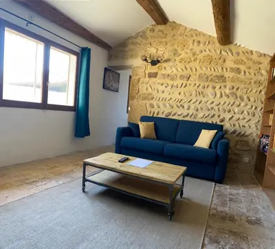 a living room with a blue couch and a coffee table at Mazet au pied des Alpilles, avec Piscine & Pétanque in Salon-de-Provence
