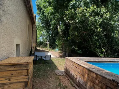 a backyard with a wooden fence and a swimming pool at Mazet au pied des Alpilles, avec Piscine & Pétanque in Salon-de-Provence