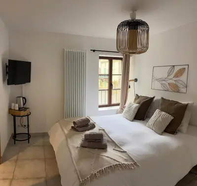 a bedroom with a large white bed with a window at L’auberge de Montsalier in Montsalier