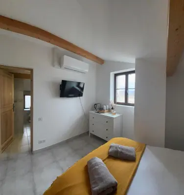 a bedroom with a bed and a tv on the wall at L’auberge de Montsalier in Montsalier