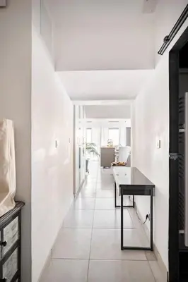 a white hallway with a table in a room at Entre Aix et Marseille in Rognac
