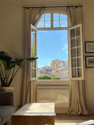 a living room with a window and a table at Le Cocon Aixois in Aix-en-Provence