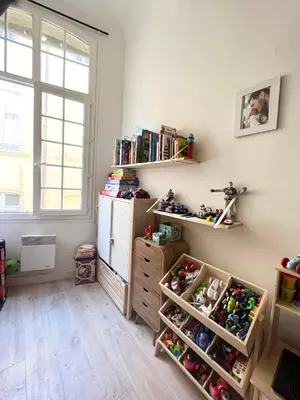 a room with a refrigerator and shelves with toys at Le Cocon Aixois in Aix-en-Provence