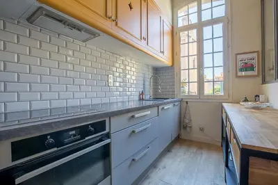 a kitchen with white cabinets and a stove top oven at Le Cocon Aixois in Aix-en-Provence