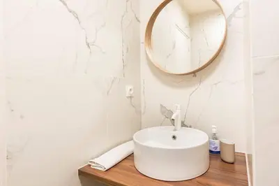 a white bathroom with a sink and a mirror at Le Forbin by La Familia in Aix-en-Provence