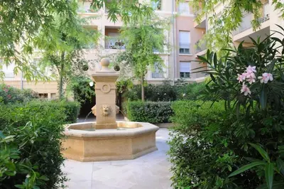 a fountain in a garden with a building in the background at Le Fernandol by La Familia in Aix-en-Provence