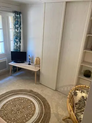 a living room with a television and a table with a rug at Le Fernandol by La Familia in Aix-en-Provence