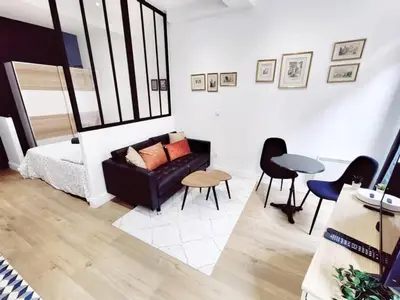 a living room with a couch and a table and chairs at Le Boulegon by La Familia in Aix-en-Provence