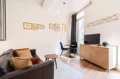 a living room with a couch and a television at Le Boulegon by La Familia in Aix-en-Provence