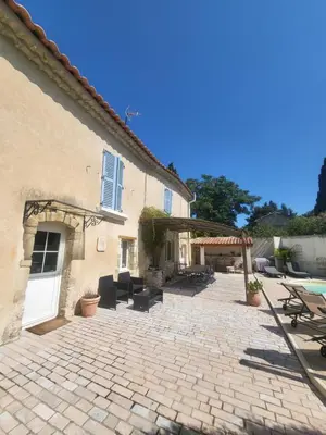 a building with a patio and a white door at Les Pagnons in Velleron