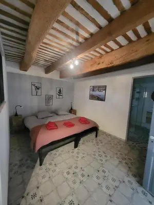 a bedroom with a large bed with red pillows on it at Les Pagnons in Velleron