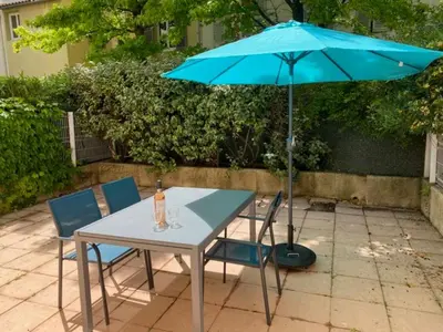 a table and chairs with a blue umbrella at le Signoret in Aix-en-Provence