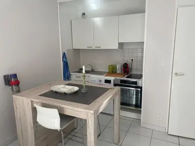 a kitchen with a wooden table and white cabinets at le Signoret in Aix-en-Provence