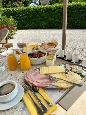 a table with a breakfast of bread and fruit and juice at Chambre d'hôtes Alizé, Le Moulin de Prédelles in Reillanne