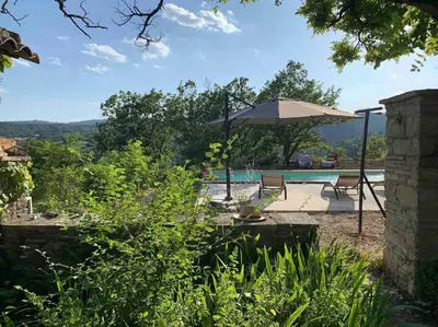 a patio with an umbrella and a swimming pool at Provencal farmhous Lubéron, swimming pool in Revest-des-Brousses