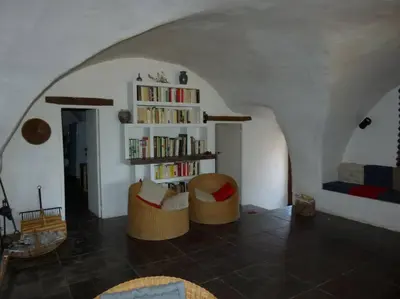 a living room with two chairs and a book shelf at Provencal farmhous Lubéron, swimming pool in Revest-des-Brousses