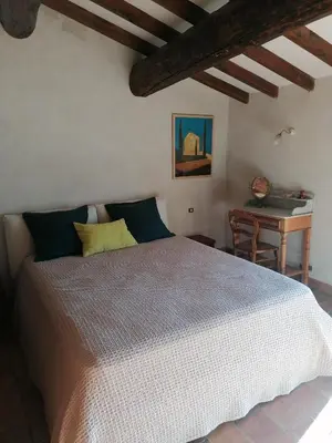 a bedroom with a large bed and a desk at Chambre d'hôte in Crillon-le-Brave