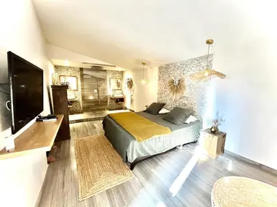 a bedroom with a bed and a flat screen tv at Maison en pierre avec piscine, 6 couchages, située au cœur de Mallemort, Provence. - FR-1-658-25 in Mallemort