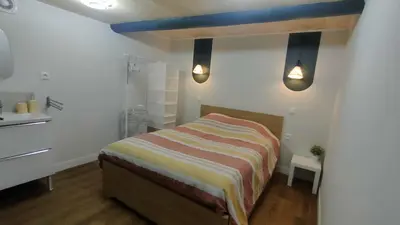 a small bedroom with a bed and a sink at Studio rénové maison de village du Luberon in Villelaure