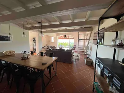 a living room with a table and a couch at Proche Roussillon, La villa rouge Luberon, piscine chauffée, climatisation et vue Luberon in Gargas