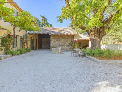 a house with a courtyard with a table and a tree at Holiday Home Le Mas de Marius by Interhome in Cavaillon