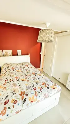 a bedroom with a bed with a floral bedspread at Les Iris in Céreste