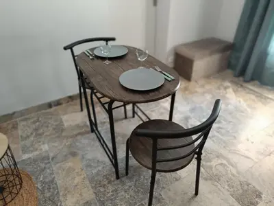 a wooden table with two chairs and wine glasses on it at Écrin de nature sous les pins in Aurons