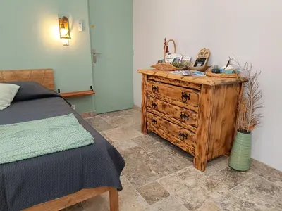 a bedroom with a bed and a wooden dresser at Écrin de nature sous les pins in Aurons