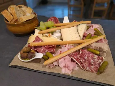 a plate of food with meat and vegetables and chop sticks at Écrin de nature sous les pins in Aurons