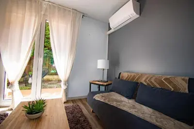 a living room with a couch and a large window at Les quatres loges in Aix-en-Provence
