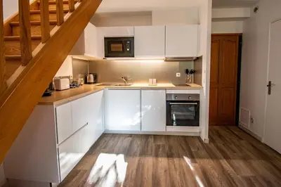 a kitchen with white cabinets and a staircase at Les quatres loges in Aix-en-Provence
