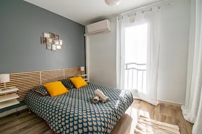 a bedroom with a bed with yellow pillows and a window at Les quatres loges in Aix-en-Provence