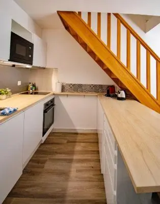 a kitchen with a wooden counter top and a staircase at Les quatres loges in Aix-en-Provence