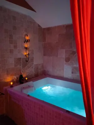 a hot tub in a room with a red curtain at Une Parenthese pour Deux in Plan-dʼOrgon