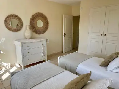 a bedroom with two beds and two mirrors on the wall at La Villa Baronnette in Cabrières-dʼAvignon