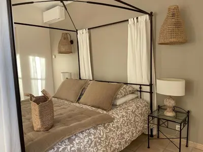 a bedroom with a canopy bed and a table at La Villa Baronnette in Cabrières-dʼAvignon