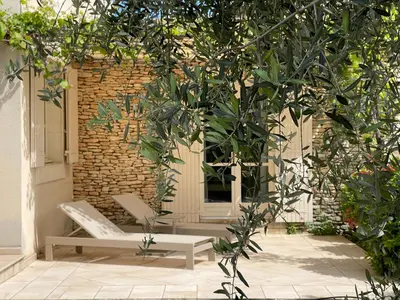 a patio with two benches in front of a brick wall at La Villa Baronnette in Cabrières-dʼAvignon