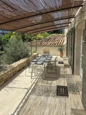 a patio with a table and chairs under a pergola at Mas Cerisiers in Saint-Martin-de-Castillon