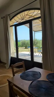 a dining room with a table and a large window at Rêve en Lubéron in Lauris