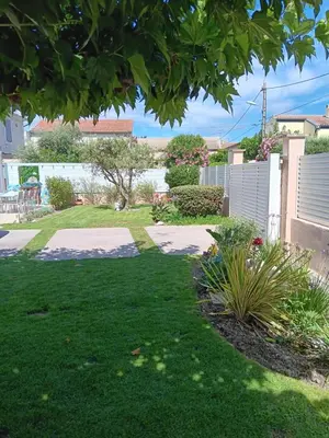 a yard with green grass and a fence at La villa MARIE in Cavaillon