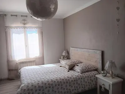 a bedroom with a bed and a large window at La villa MARIE in Cavaillon