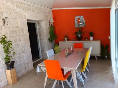 a dining room with orange chairs and a table at La villa MARIE in Cavaillon