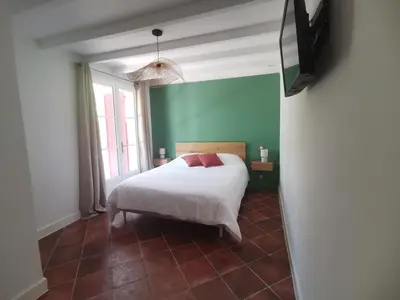 a bedroom with a bed and a flat screen tv at LA GRANGETTE in Velleron