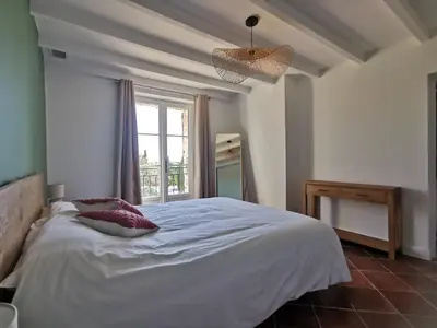 a bedroom with a large white bed with a window at LA GRANGETTE in Velleron