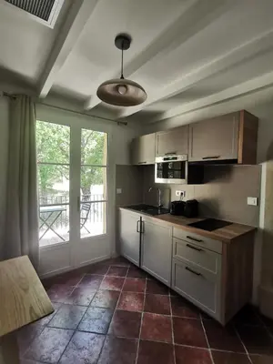 a kitchen with white cabinets and a large window at LA GRANGETTE in Velleron
