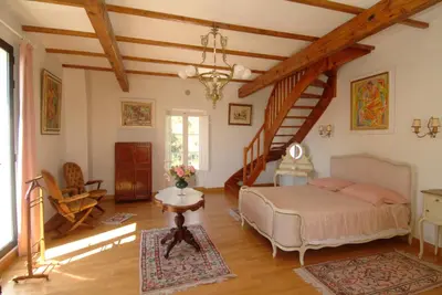 a bedroom with a bed in a room with a staircase at Pavillon de Beauregard in Aix-en-Provence